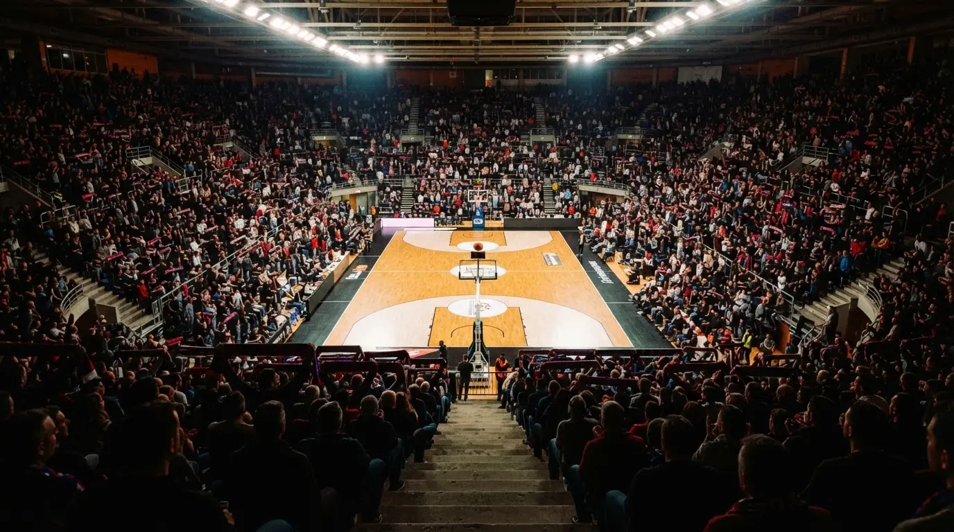A packed sports hall under floodlights photographed from a long way off